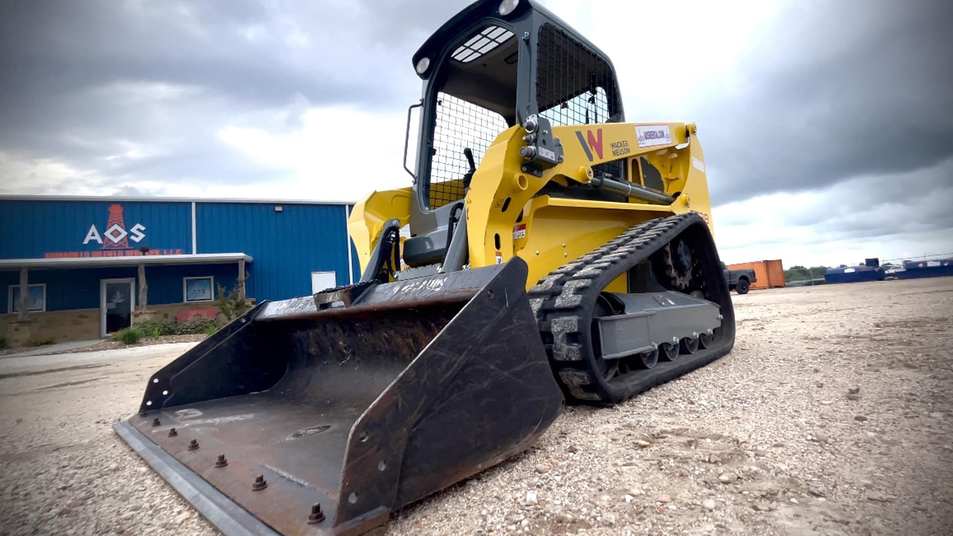 Yellow skid steer compact track loader in the parking lot