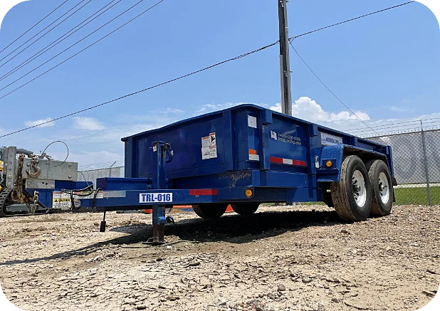 Blue dump trailer parked on gravel