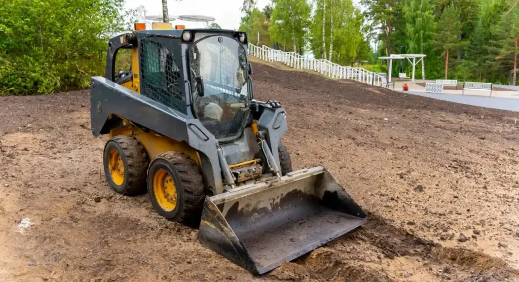 Gray Skid Steer Loader with Bucket at Landscaping Project Site